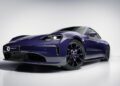 A dark blue Porsche Taycan electric sports car, photographed from a low front angle in a studio setting, showcases the signature elegance and innovation of Porsche Italia.