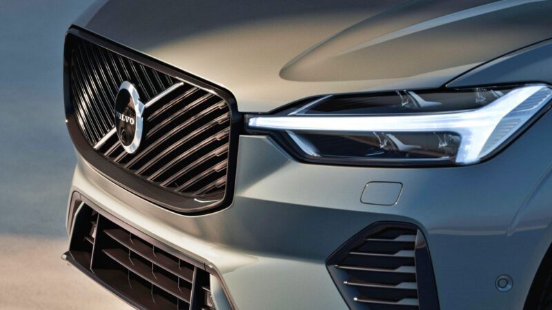 Close-up of the front grille and headlight of a gray Volvo car, highlighting the Volvo logo and sleek design—part of Volvo’s 2026 Hybrids, which get smarter with big tech OTA upgrades for 2.5 million existing cars.