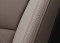 Close-up of taupe-colored leather car seat with detailed contrast stitching in a crisscross pattern, reflecting the refined craftsmanship found in Volvo’s 2026 Hybrids, which get smarter with Big Tech OTA upgrades for 2.5 million existing cars.