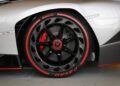 Close-up of a Lamborghini car wheel with red and black Pirelli P-Zero tire and visible brake caliper, set against a gray and white vehicle body—a striking detail at Monterey Car Week.