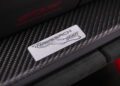 Close-up of a metallic "Weissach RS" badge on a carbon fiber door sill, with partial red "GT3 RS" and "Porsche Experience Center Toronto" text visible above—showcasing the exclusive 911 GT3 RS.