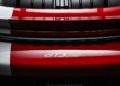 Close-up view of the rear end of a 911 GT3 RS with visible aerodynamic features and "Sonderwunsch" branding, captured at the Porsche Experience Center.