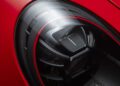Close-up of a modern car headlight with a sleek, circular design on a red 911 GT3 RS, highlighting its stunning detail at the Porsche Experience Center.