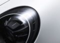 Close-up view of a modern car's headlight on a white vehicle, showcasing detailed contours and reflective surfaces, similar to the precision found on the Porsche 911 GT3 RS at the Porsche Experience Center.
