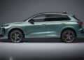 Side view of the 2026 Audi Q3 Breaks Cover: Here's What's New—a metallic green SUV with black roof, large alloy wheels, and red brake calipers, set against a plain gray background.