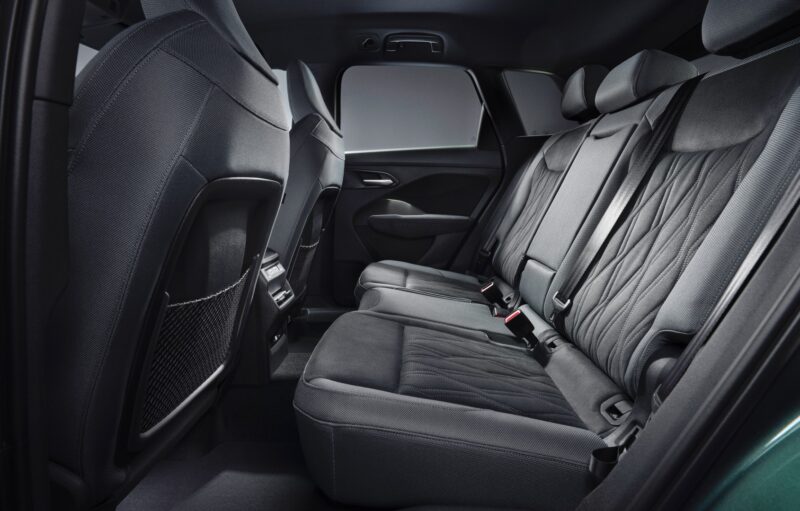 The image shows the backseat interior of a modern car with three black fabric seats, seatbelts, and door trim visible—possibly offering a glimpse of what to expect as the 2026 Audi Q3 breaks cover: here's what's new.