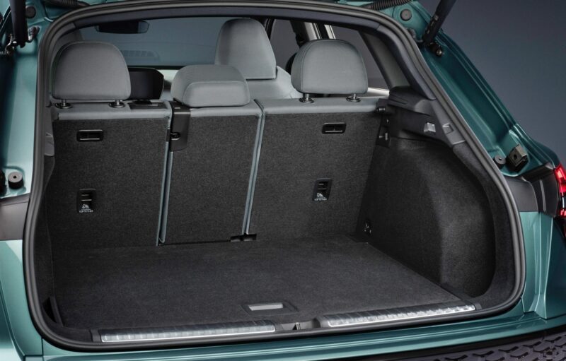 Open rear hatchback of the 2026 Audi Q3 Breaks Cover: Here's What's New, showing the trunk area with both back seats upright, revealing a spacious, carpeted cargo space with seat release mechanisms visible.