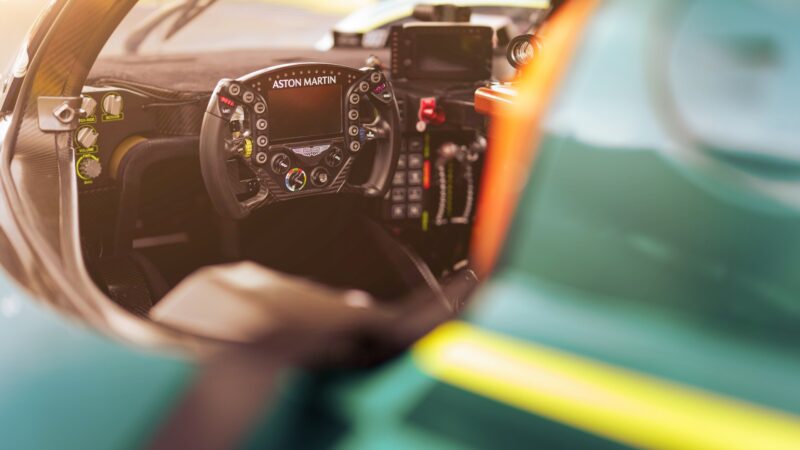 Close-up view of the track-only Valkyrie LM, Aston Martin's latest hypercar with Le Mans DNA, focusing on the race car cockpit, steering wheel with buttons and displays, and advanced dashboard controls.