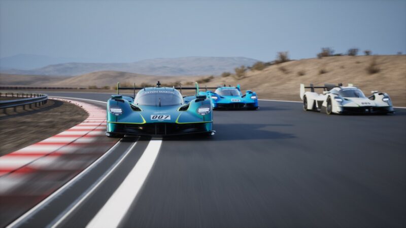 Three race cars speed along a curved desert track, with the lead car—number 007—resembling the limited to 10, track-only Valkyrie LM, Aston Martin's latest hypercar infused with Le Mans DNA.