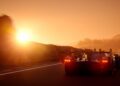 A track-only Valkyrie LM, Aston Martin's latest hypercar with Le Mans DNA, speeds down the road at sunset, its sleek form bathed in bright sunlight from the left.