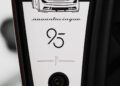Close-up of a car plaque displaying "Battista 1930," a car illustration, "novantacinque," the number 95, and a small camera or sensor beneath the text—celebrating the exclusive Pininfarina Battista Novantacinque.