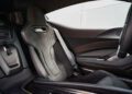 Driver's seat and interior of the last Battista Novantacinque, a modern sports car featuring black suede upholstery, detailed stitching, and visible carbon fiber accents.
