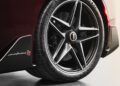 Close-up of a high-performance car's rear wheel and tire, featuring a large brake disc and caliper, with the "Pininfarina Battista" badge and "pininfarina 95" visible on the body panel.