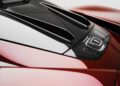 Close-up of the rear engine cover of a red Pininfarina Battista, featuring aerodynamic vents and a sleek, glossy finish.