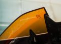 Close-up of a car panel featuring the "Battista Novantacinque" logo in white against a yellow and orange gradient background, celebrating the legacy of Pininfarina Battista.