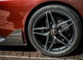Close-up of a Pininfarina Battista’s rear wheel, featuring a Michelin Pilot Sport Cup 2 tire, carbon fiber bodywork, and the distinctive Pininfarina badge—an iconic detail from the Last Battista.