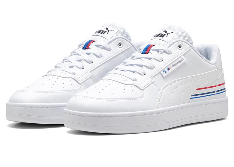 A pair of white Motorsport PUMA sneakers with perforated toes, blue and red stripe accents, and a Puma logo on the tongue—perfect driver shoes for those seeking the best PUMA sneakers style.