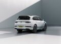 A white Bentley Bentayga Speed SUV is parked in a minimalist, well-lit space, viewed from the rear three-quarter angle.