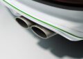 Close-up view of dual exhaust pipes on a white, powerful Bentayga, featuring a green accent stripe and "Bentley" branding on the exhaust tips.