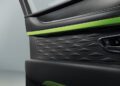 Close-up of a car door interior with black quilted leather, green accents, and visible door lock and handle buttons, showcasing the luxury craftsmanship found in the powerful Bentayga.