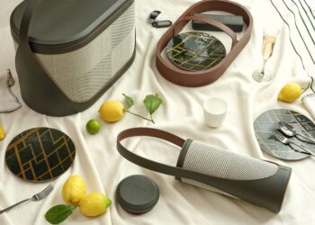 Picnic setup featuring the Hyde Picnic Collection from Bentley Home: modern baskets, lemons, geometric plates, a glass of champagne, cup, and key—all beautifully arranged for elevated outdoor living on a light-colored blanket.