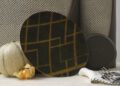 A patterned oval plate, a melon, a physalis, two forks, and two textured containers from the Hyde Picnic Collection are arranged on a light fabric surface, capturing the spirit of refined Outdoor Living.