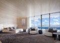 Spacious modern bedroom in this $37.5M Penthouse at Bentley Residences Miami, featuring large windows, contemporary furniture, and an ocean view. Bed, chairs, and tables are arranged on a neutral-toned carpet.