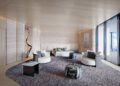 Spacious modern penthouse bedroom with neutral tones, large bed, armchairs, round rug, abstract decor, and floor-to-ceiling windows overlooking the ocean at Bentley Residences Miami. Stunning $37.5M luxury living.