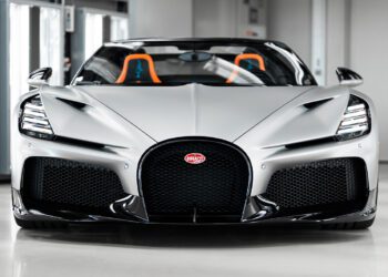Front view of a silver $5M Bugatti Mistral with black grille and orange-accented seats, parked indoors—captured by Matt Argent.