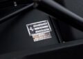 Close-up of a metal VIN and specification plate on a black surface, displaying details of a Ferrari 365 GTB/4 Daytona, including model, engine, and chassis numbers—an icon admired by Ferrari Beverly Hills collectors.