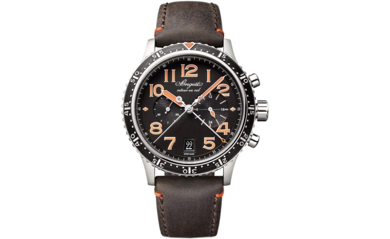 A wristwatch with a black dial, orange accents, three subdials, date display, and a brown leather strap with orange stitching—an eye-catching choice among the best luxury watches.