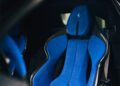Close-up of a car seat upholstered in bright blue suede with black accents, featuring a prancing horse logo embroidered on the headrest—an exquisite detail from the powerful 819HP 12Cilindri at Miller Motorcars.