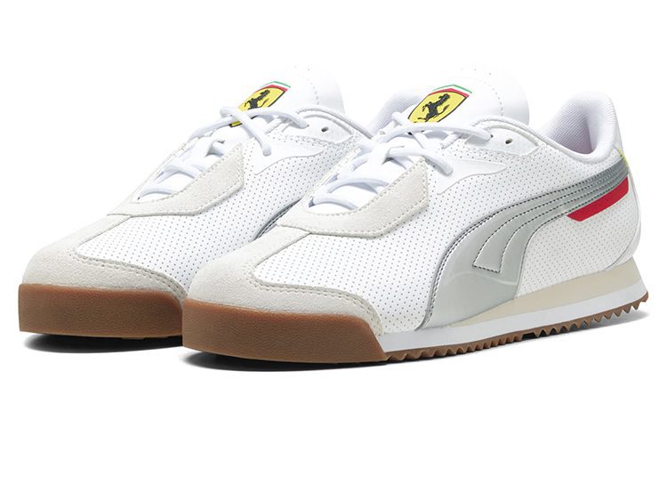 A pair of white PUMA sneakers with a perforated texture, silver accents, gum soles, and the Ferrari logo on the tongue—crafted for the ultimate driver and inspired by iconic motorsport style.