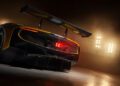 A close-up view of the rear of a black and yellow Ferrari 296 GT3 Evo with a large rear wing, taken indoors under bright stage lights during the Ferrari unveiling.