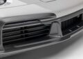 Close-up of a car's front bumper featuring carbon fiber detailing, large air vents, and a splitter—showcasing performance design in the style of Gunther Werks Goes Modern: Meet GW9’s Carbon-Clad 992 Turbo S.
