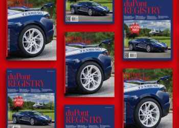 Several copies of the duPont REGISTRY July 2025 magazine, showcasing a blue Yenko/SC car on the cover, are arranged on a striking red background.