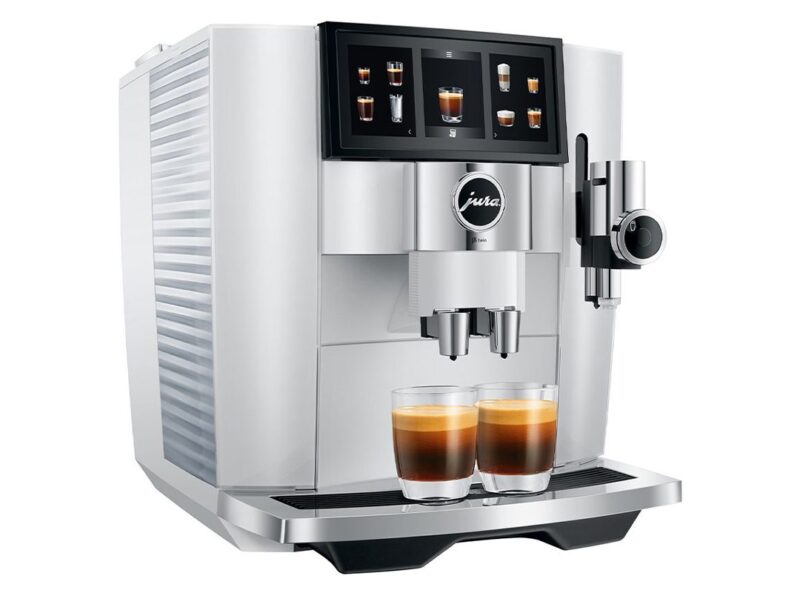 A white Jura coffee machine with a digital display is dispensing two espresso drinks into clear glass cups—a sleek addition featured in the duPont REGISTRY Father's Day Gift Guide.