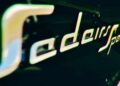 Close-up of a metallic badge on a vehicle that reads "Sedan Speed" in stylized lettering, echoing the precision of Farewell Jesko: Enter Track-Focused 1625 HP Koenigsegg Sadair's Spear.