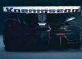 Rear view of a black Koenigsegg sports car with a large rear wing and "Koenigsegg" branding, showcasing aerodynamic features reminiscent of the Farewell Jesko: Enter Track-Focused 1625 HP Koenigsegg Sadair's Spear, with striking rear lights.