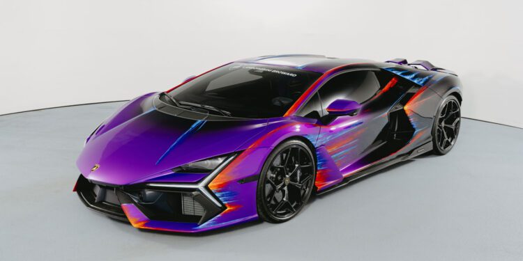 A Lamborghini Revuelto in a studio, featuring a glossy purple Opera Unica paint job with striking orange and blue accents, created to celebrate the 60th Anniversary.