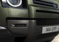 Close-up view of the front grille, headlight, and license plate of a green Land Rover Defender Refreshed: Here's What’s New For 2026, with the registration number "144 UYP.