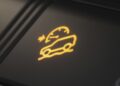 Illuminated dashboard icon showing a car with wavy lines and a speedometer, indicating cruise control is active on a slippery road—a useful feature in the Land Rover Defender Refreshed: Here's What’s New For 2026.