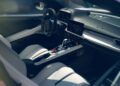 Interior view of a modern car featuring a digital dashboard, touchscreen displays, white leather seats, and a central console with gear selector and controls.