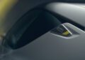 Close-up of a sleek car with a badge reading "ENVIA PHOENIX" near the side mirror, highlighting the vehicle's modern design and smooth metallic surface.