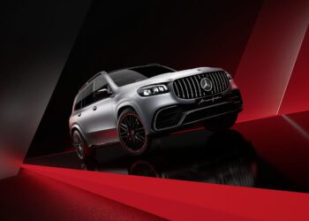 A limited edition Mercedes-AMG GLS 63 in Arctic Silver Edition with sleek black rims is showcased on a glossy black and red geometric background.