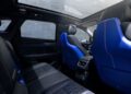 Interior view of a modern Cadillac showcases black and blue leather seats, a spacious backseat area, and a large panoramic sunroof—hinting at the power of the upcoming 519HP 2026 Optiq-V.