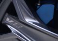 Close-up of a Cadillac car wheel featuring a "V8" emblem and a blue brake caliper in the background, hinting at the power of the 519HP 2026 Optiq-V.