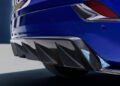 Close-up of the rear bumper and carbon fiber diffuser on a blue 2026 Optiq-V Cadillac sports car, highlighting its aerodynamic fins, part of the taillight, and impressive 519HP performance.