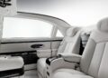 Luxurious Mercedes-Maybach G650 For Sale: car interior featuring two white leather seats, a central armrest with controls, and high-end finishes on the doors and panels.
