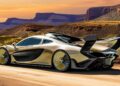 A gold and black McLaren P1 EVO sports car, designed by Frank Stephenson, with a large rear wing is parked on a dirt road in a desert landscape with mesas in the background.